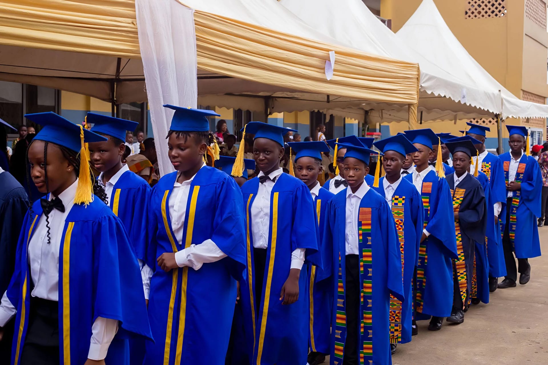 Divine International School pupils during graduation: younger student walk up close up.